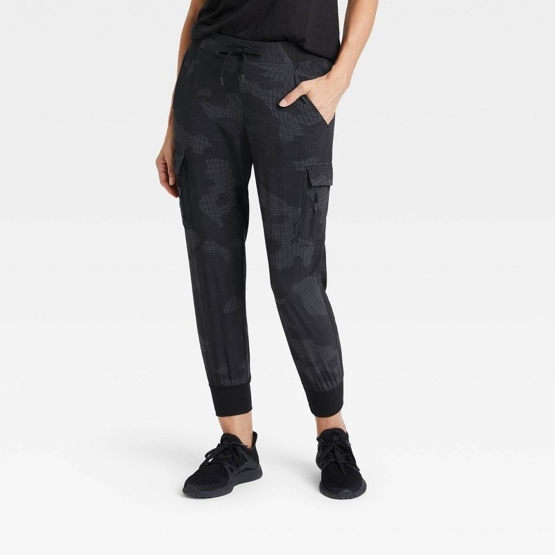 Model wearing the dark gray stretch woven cargo pants