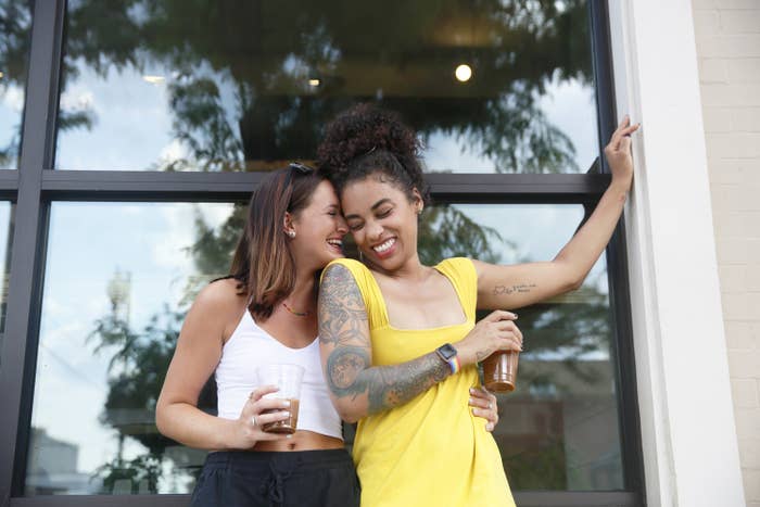 A couple holding each other while they drink coffee