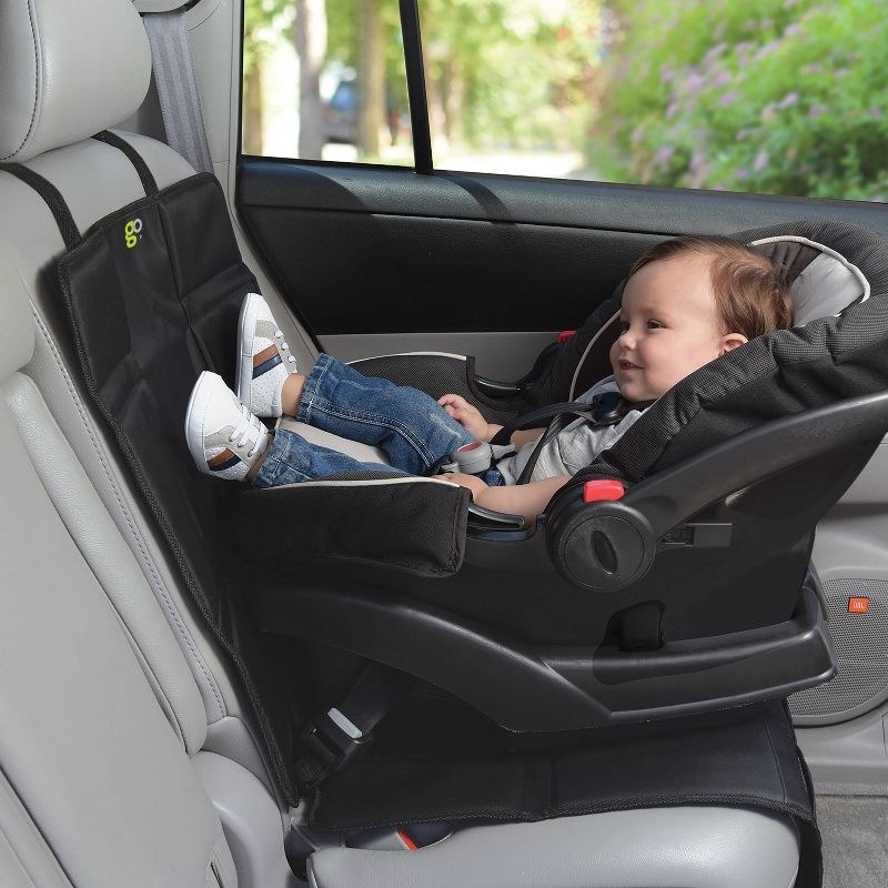 a baby in a rear facing seat on top of the seat cover