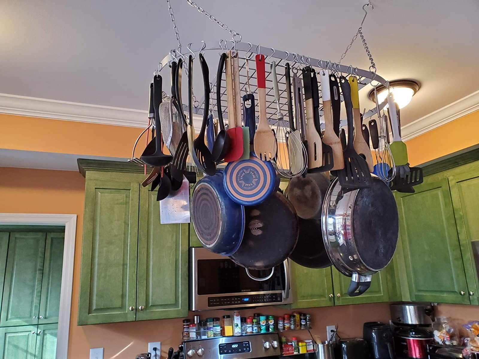 a ceiling rack holding pots, pans, and kitchen tools