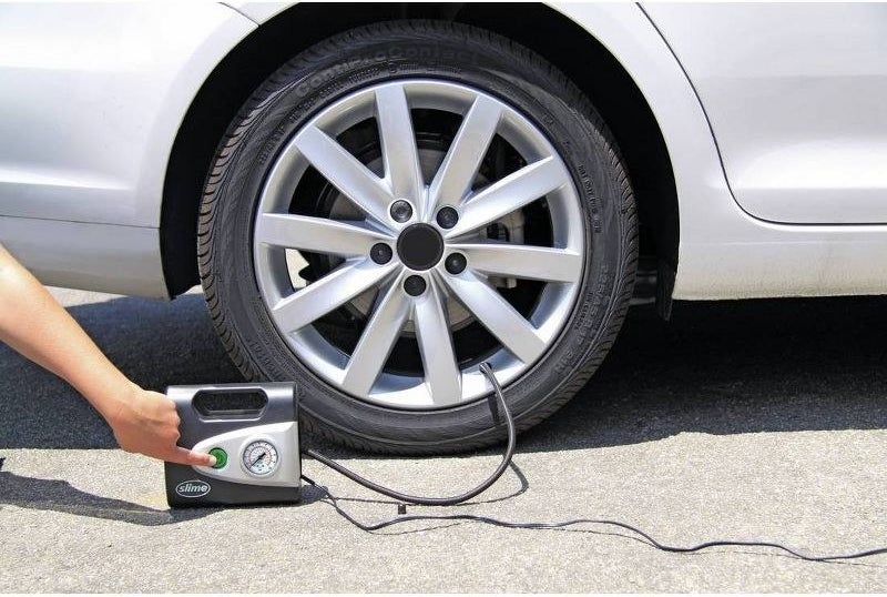 a model using the inflator on a car tire