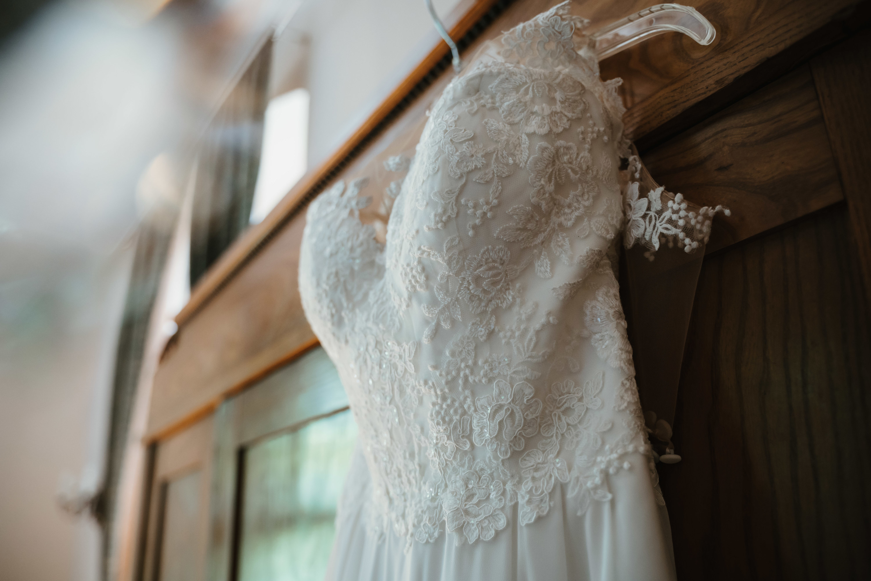 A wedding dress hanging on a mantle