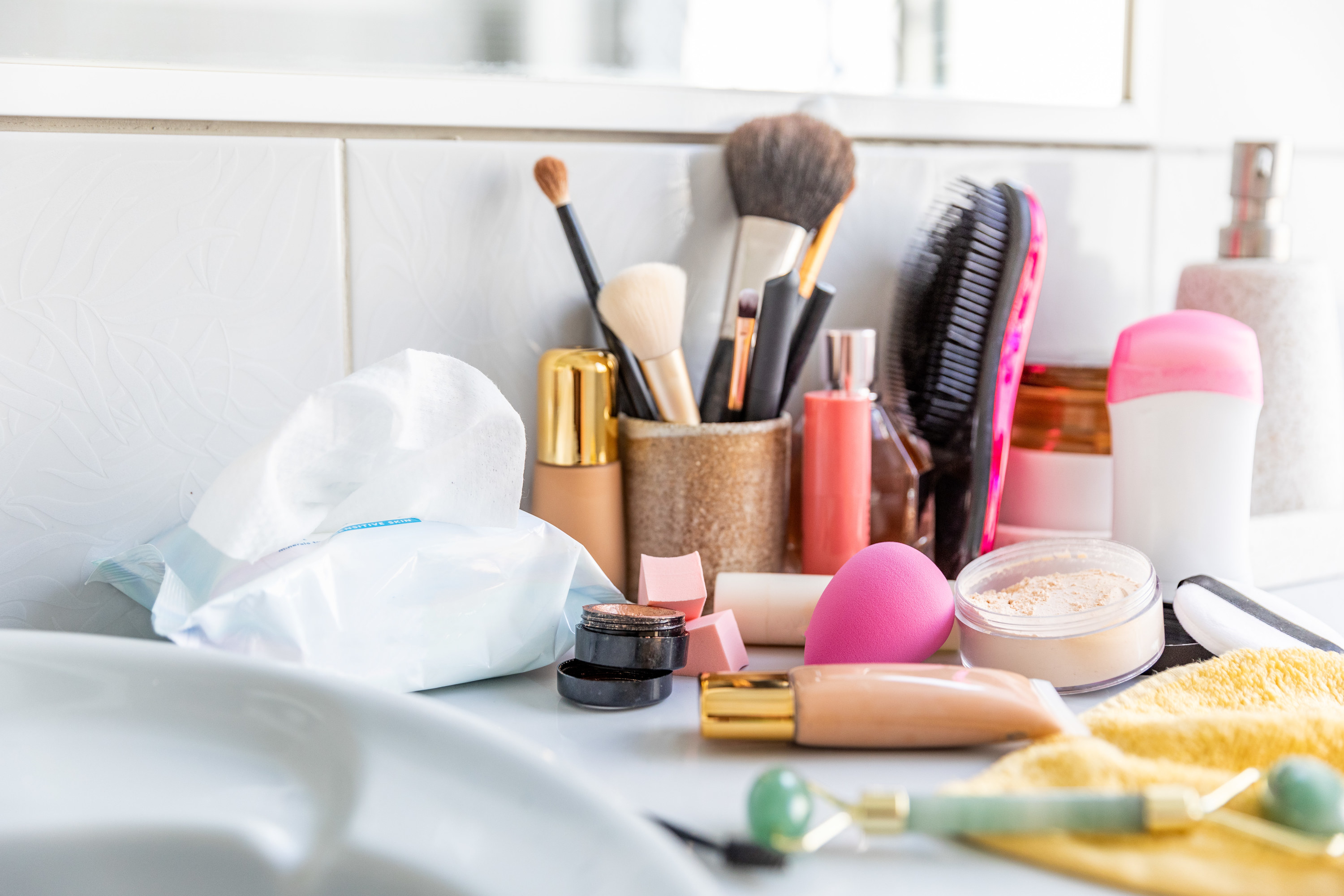 Makeup products strewn aroudn a sink