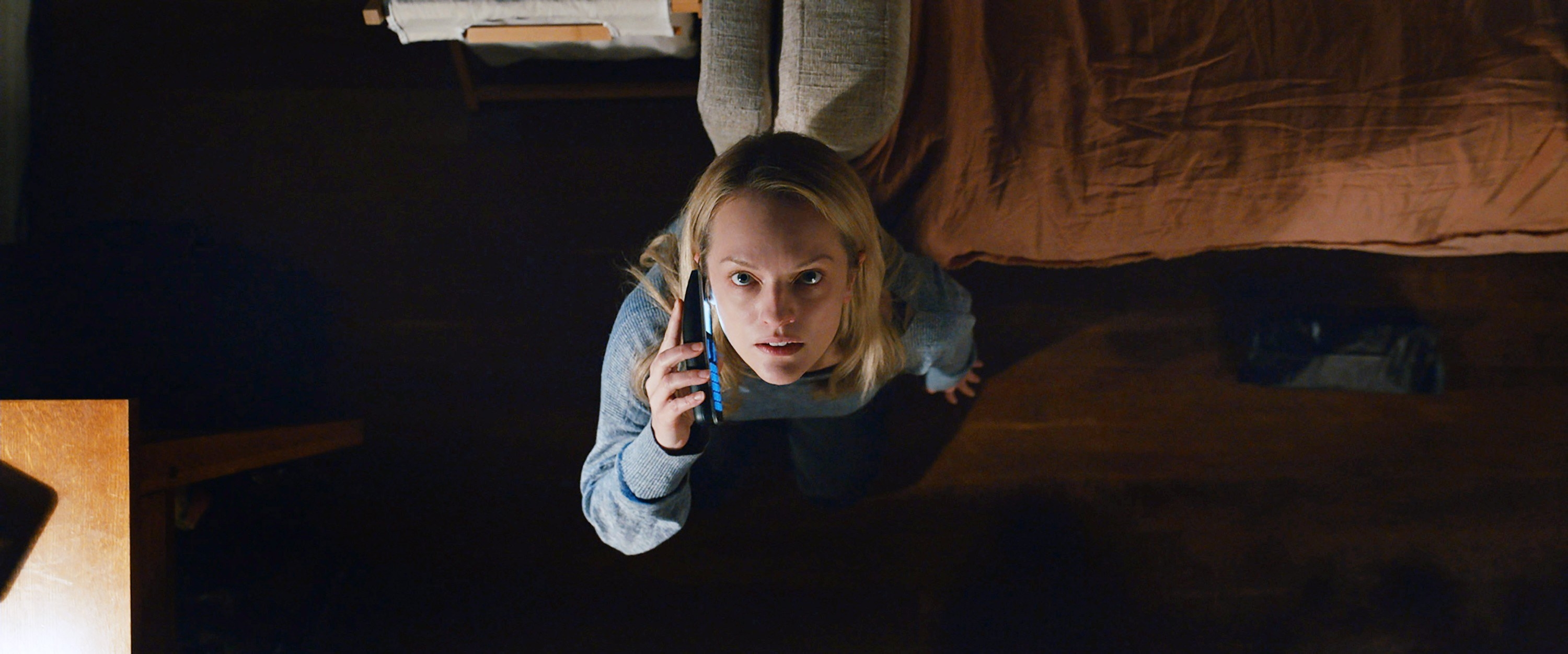Elizabeth Moss looks up at the ceiling while on the phone