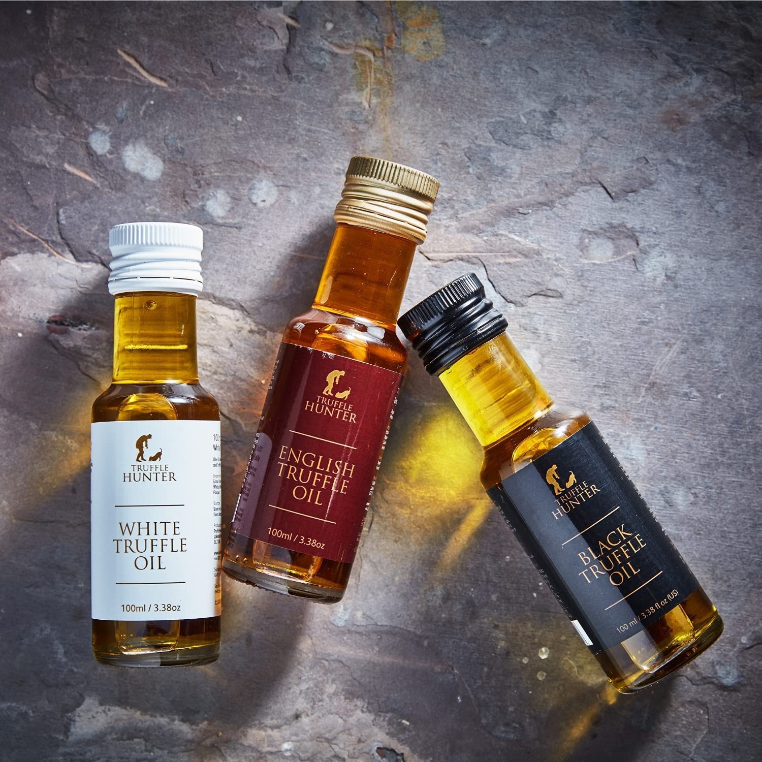 a flatlay of a truffle oil trio on a stone surface