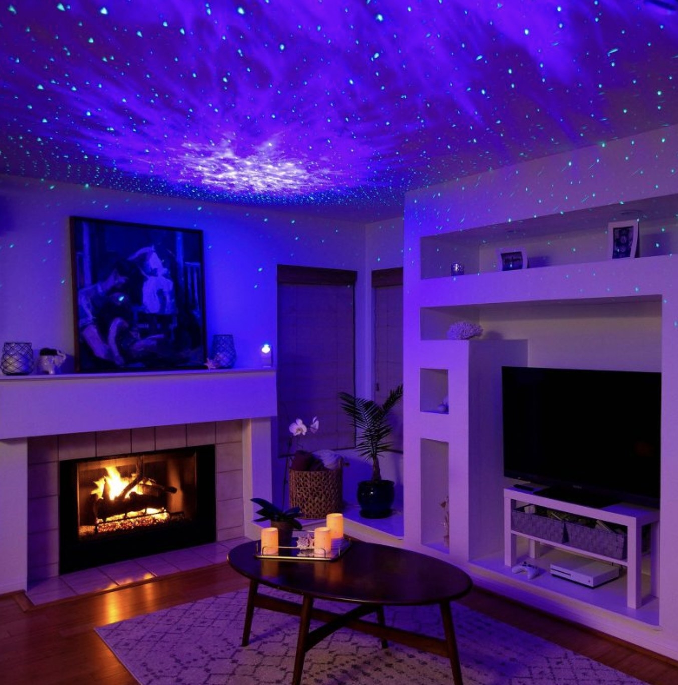 The projector creating purple blue lights on the ceiling and throughout the living room