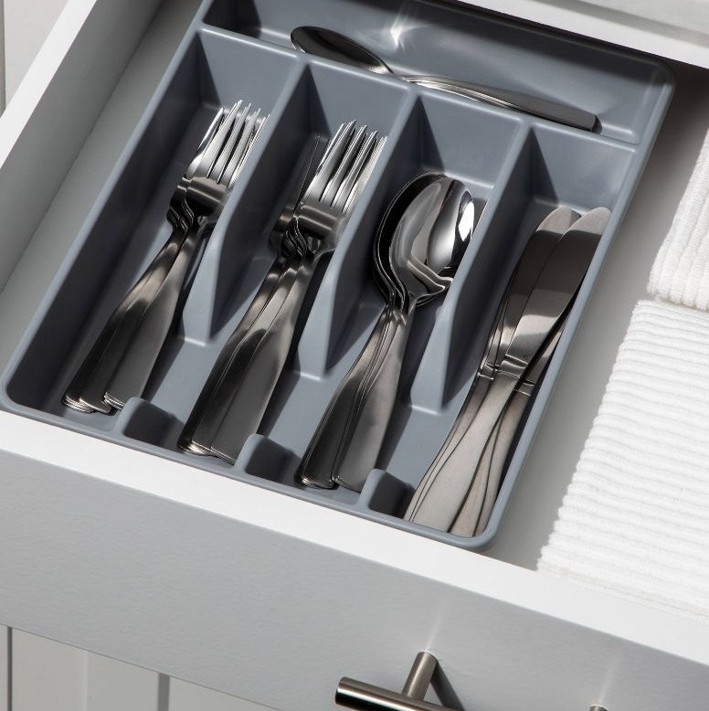 A grey utensil organizer in a drawer