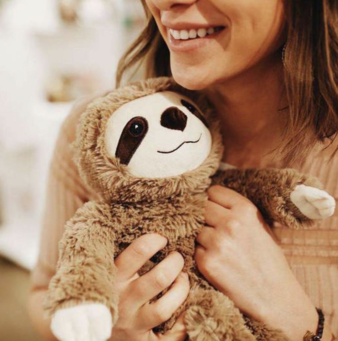 Someone holding the sloth close to her chest