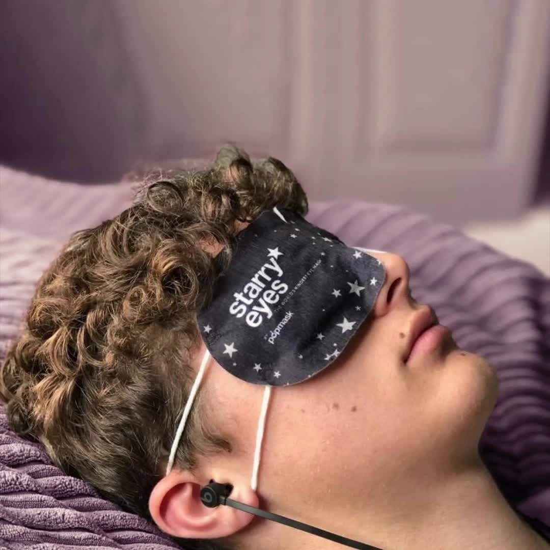 a sleeping person wearing one of the self-heating eye masks over their face