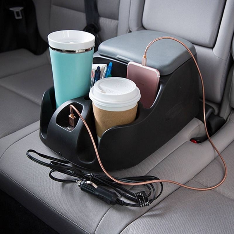 the console in a car, full of cups and devices