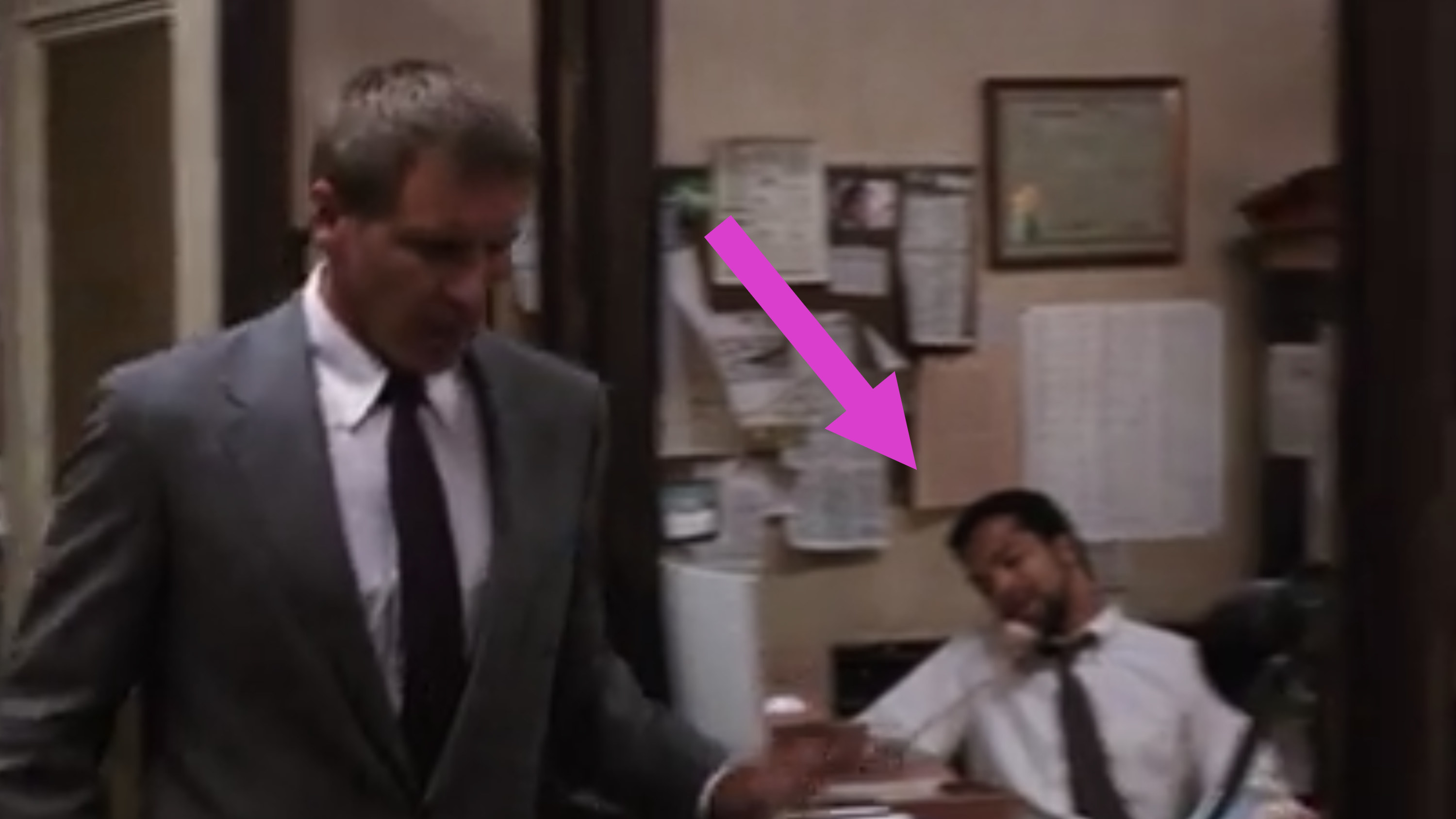 Jeffrey Wright as an attorney in the background sitting at his desk on the phone