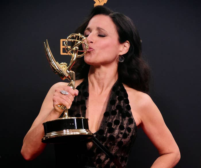 Julia Louis-Dreyfus kissing an Emmy Award