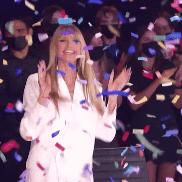 A gif of Heidi Klum jumping and clapping as confetti falls
