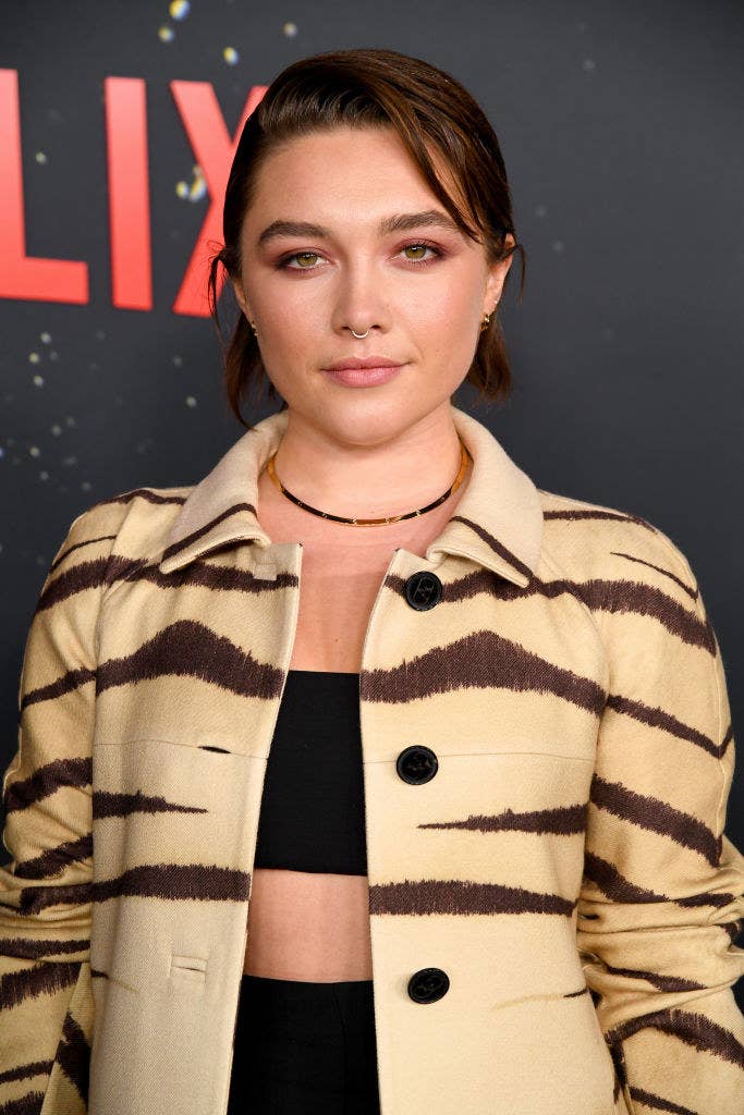 Florence Pugh at an event rocking a coat and crop top and a nose ring