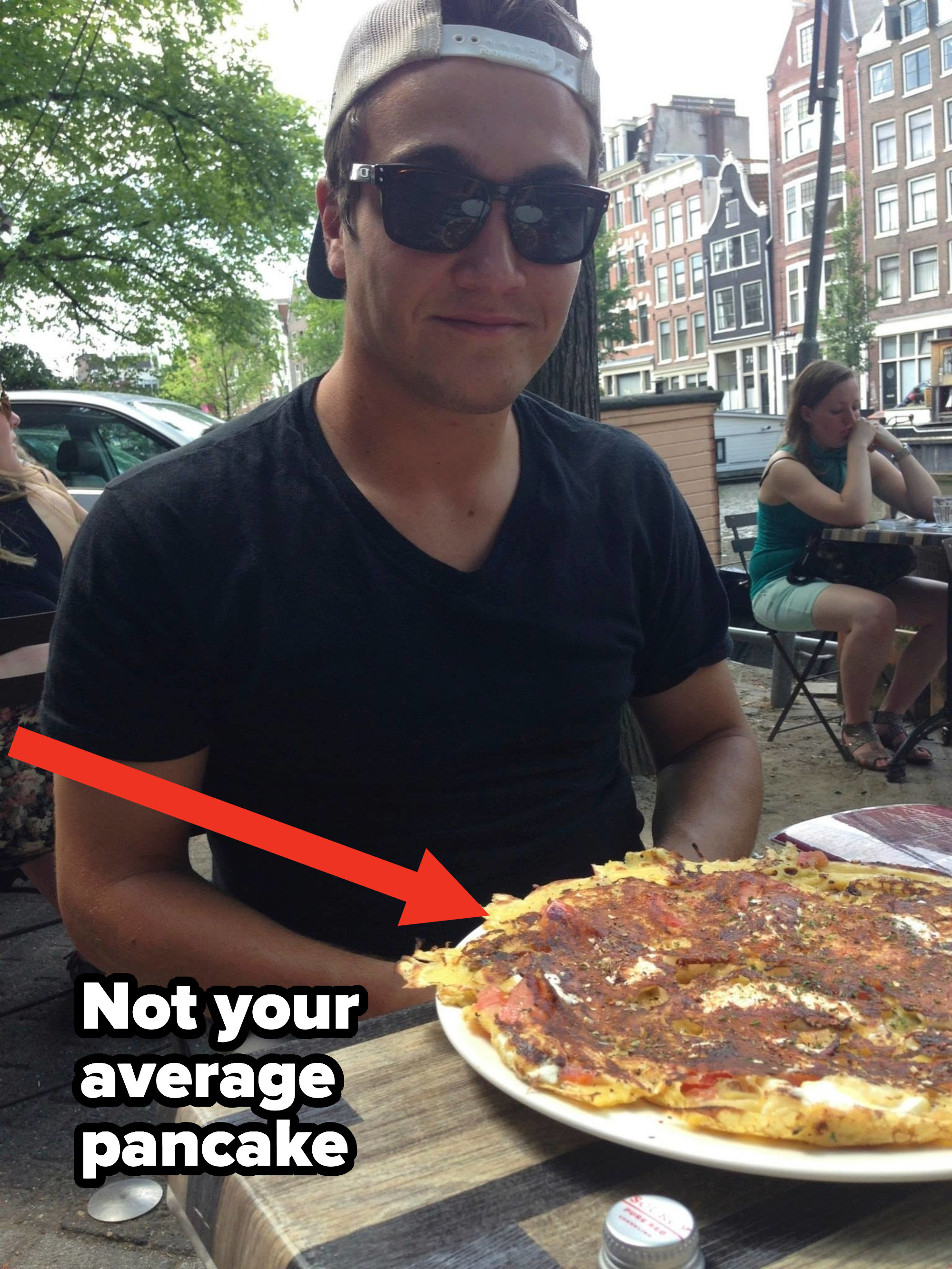 A man sitting at a table with a thin Dutch pancake