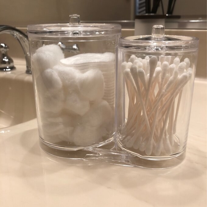 a reviewer photo of the two bathroom storage containers with cotton swabs and cotton pads inside.