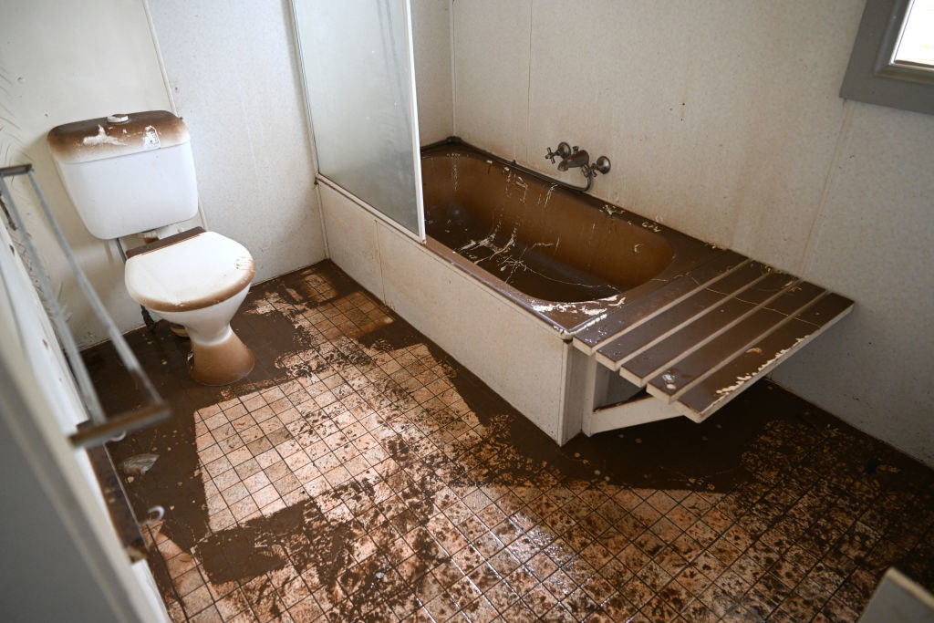 A layer of mud covers a bathroom in a flood-affected house in Lismore