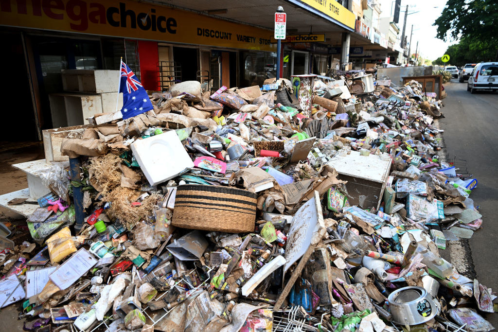 Piles of flood-damaged goods line a main street in central Lismore, Australia