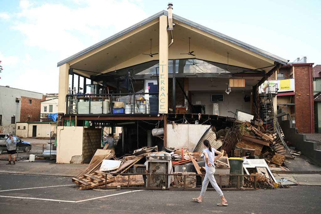 A woman walks past a flood-damaged business in central Lismore, Australia