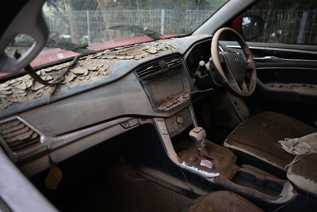 Dry mud covers the interior of a flood-damaged car