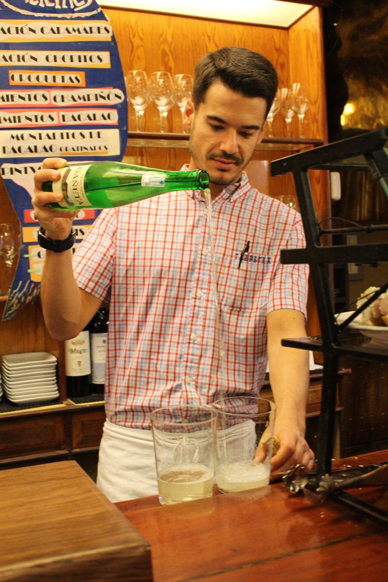 A man pouring glasses of white wine