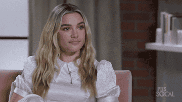Florence Pugh sitting on a couch and nodding her head