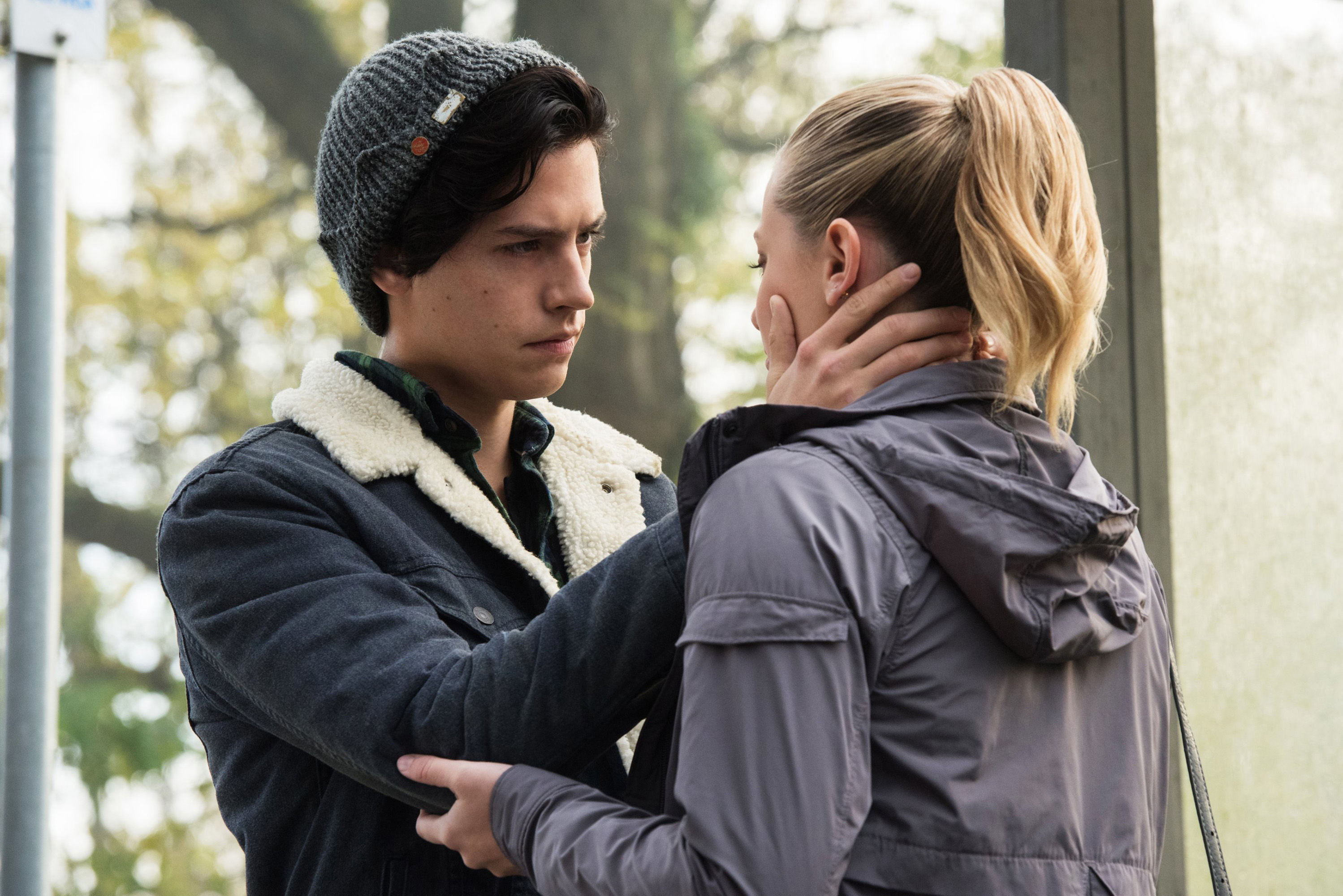 Jughead looks at Betty while holding her face in his hands