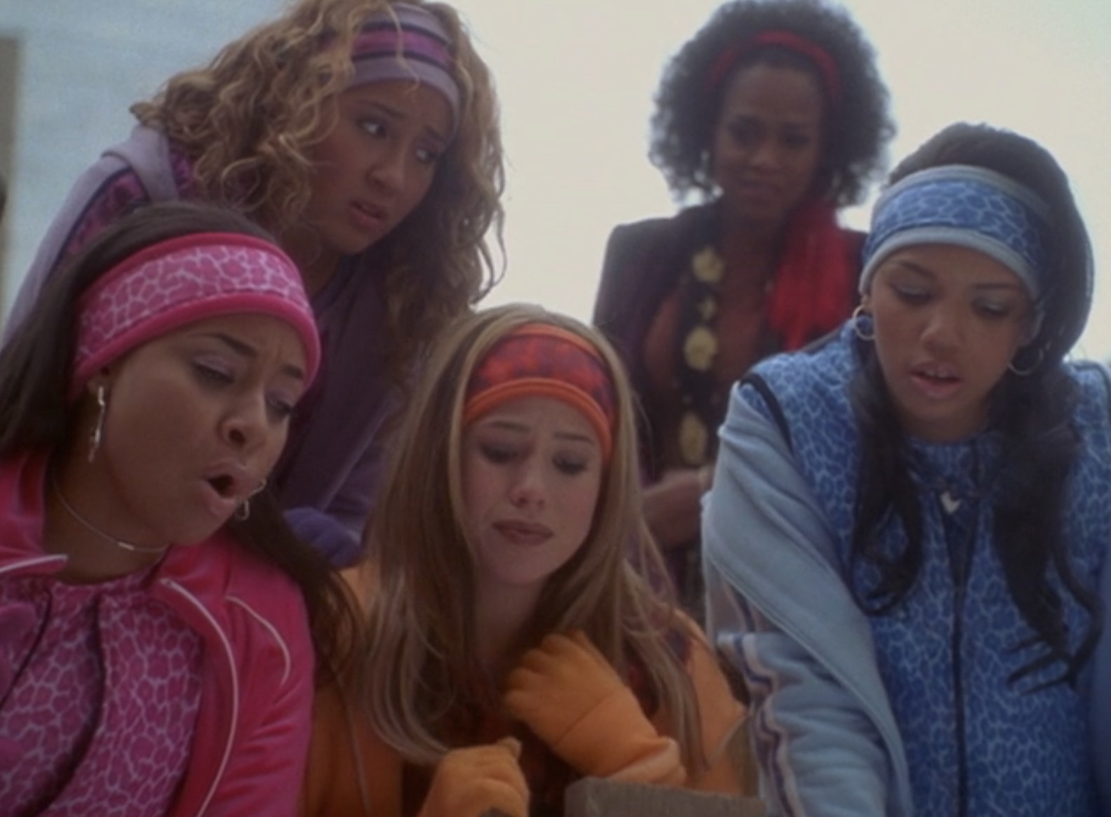 The Cheetah Girls gathered over a manhole singing to Toto