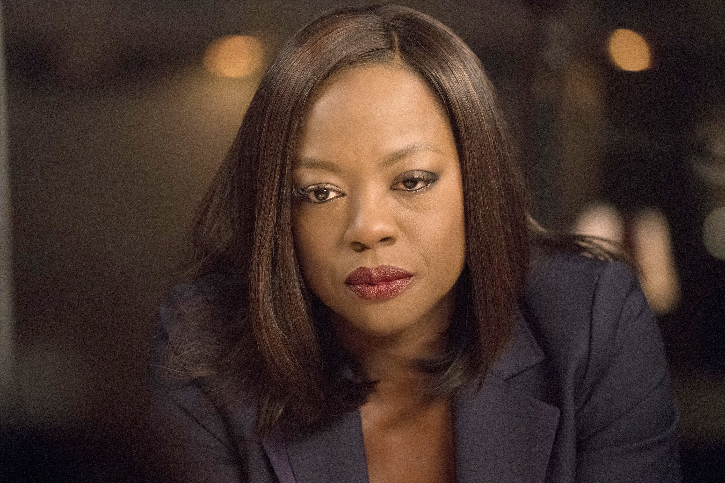 Annalise, played by Viola Davis, is wearing a red lip and a blazer while looking into the distance