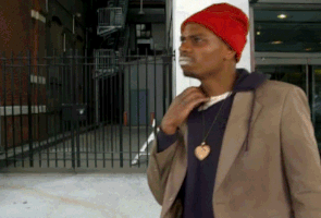 Dave Chapelle scratching his neck and pretending to be high on cocaine