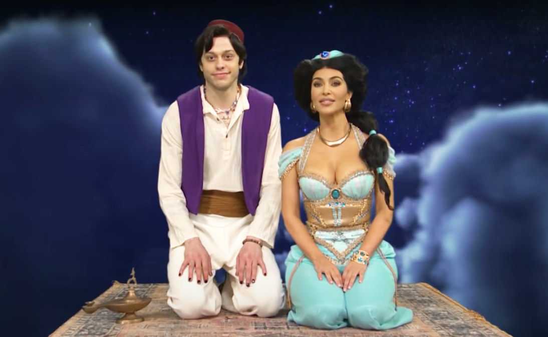 dressed as Jasmine and Aladdin, they sit together on a magic flying carpet ride