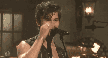 GIF Shawn Mendes singing into mic and fixing hair