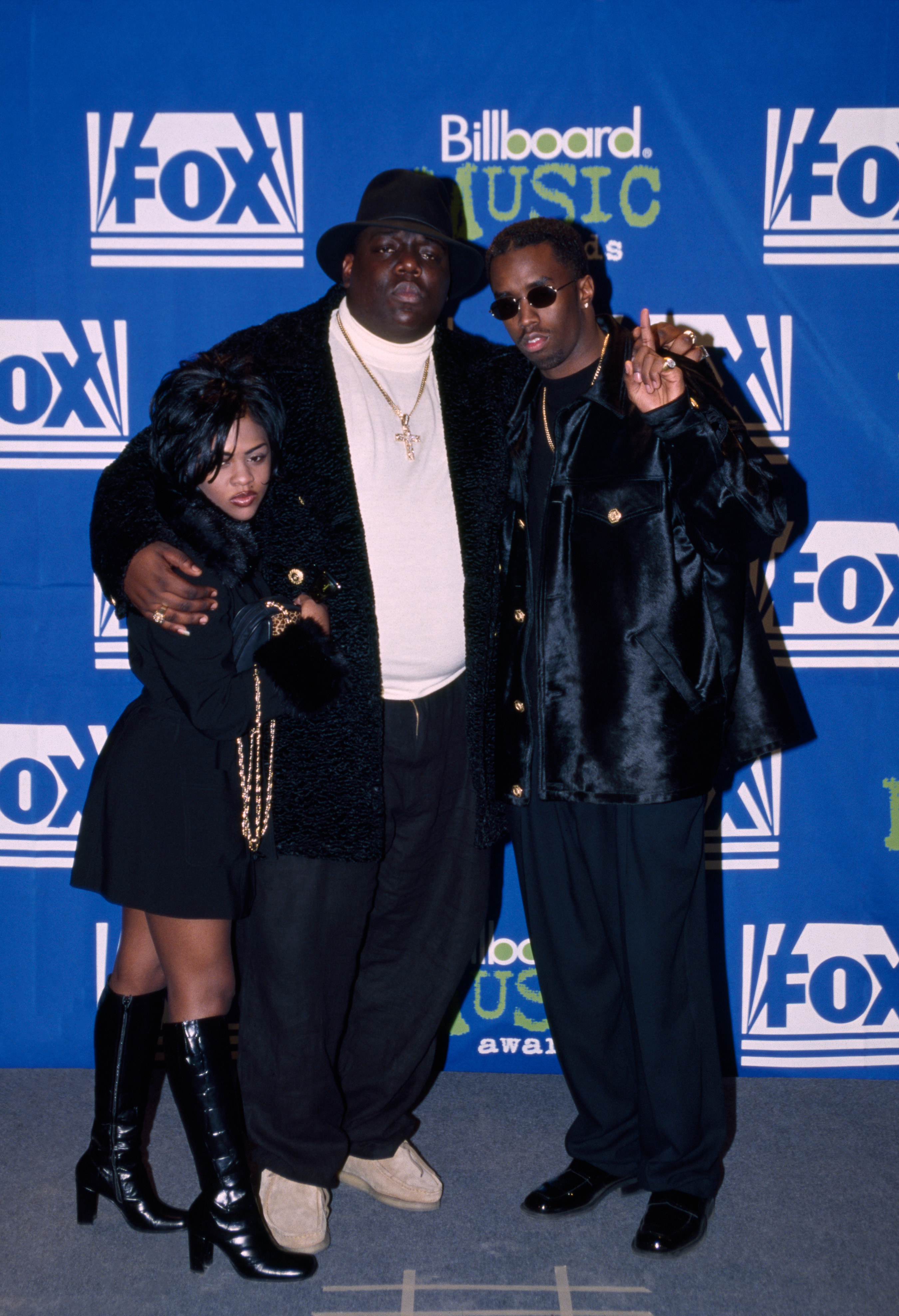 Lil&#x27; Kim, Biggie, and Puff Daddy pose at an event