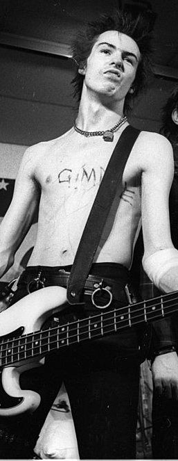 closeup of Sid playing guitar shirtless