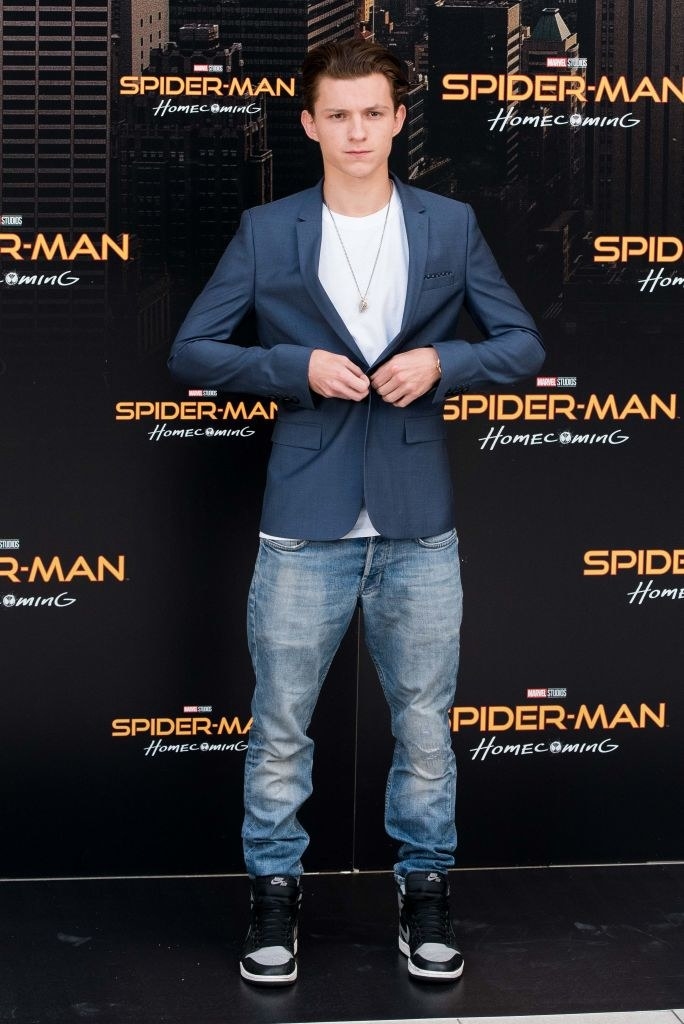 on the red carpet, Tom buttons a blazer over his plain t-shirt, which he&#x27;s wearing with baggy jeans and chunky Nikes
