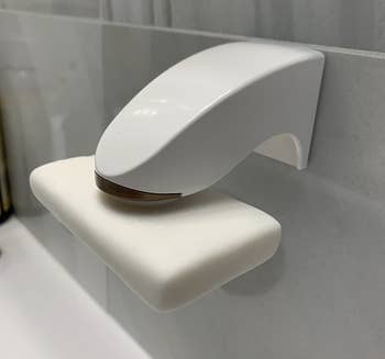 A customer review photo of the magnet on their shower wall with a bar of soap attached