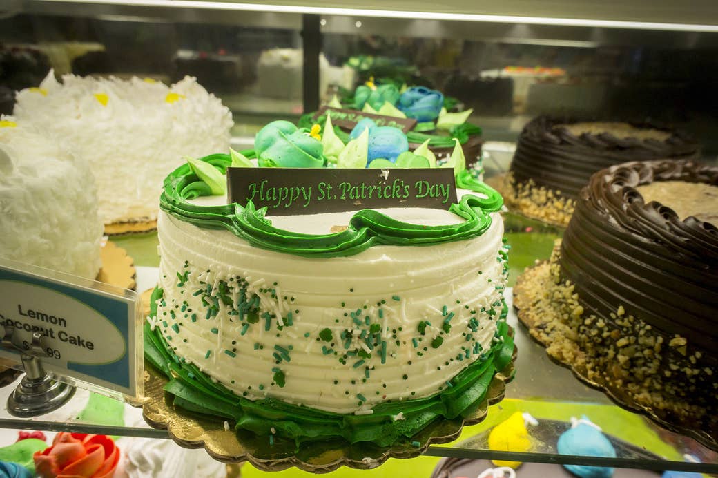 A green and white cake that reads happy saint patrick's day 