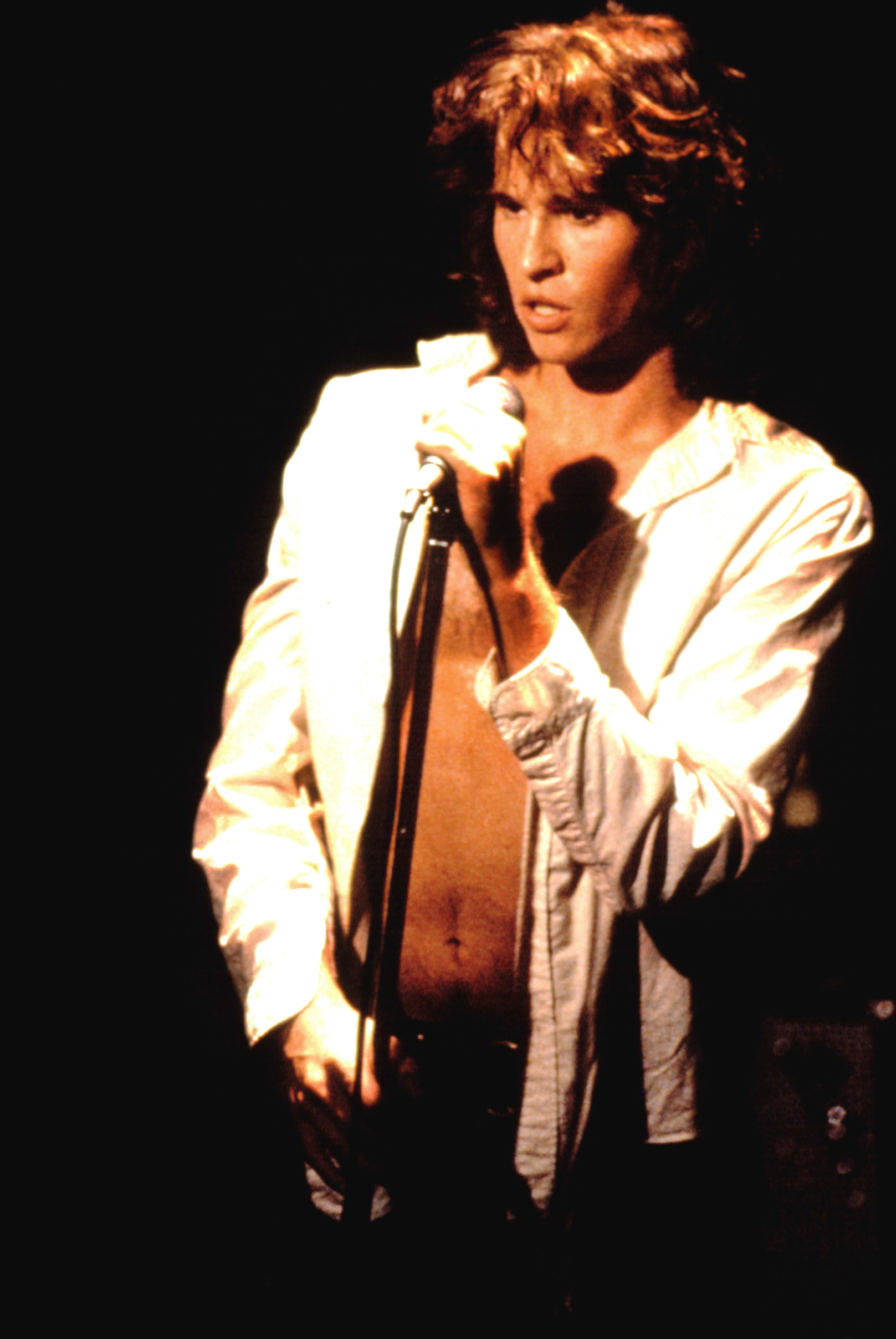 val singing on stage with his shirt open