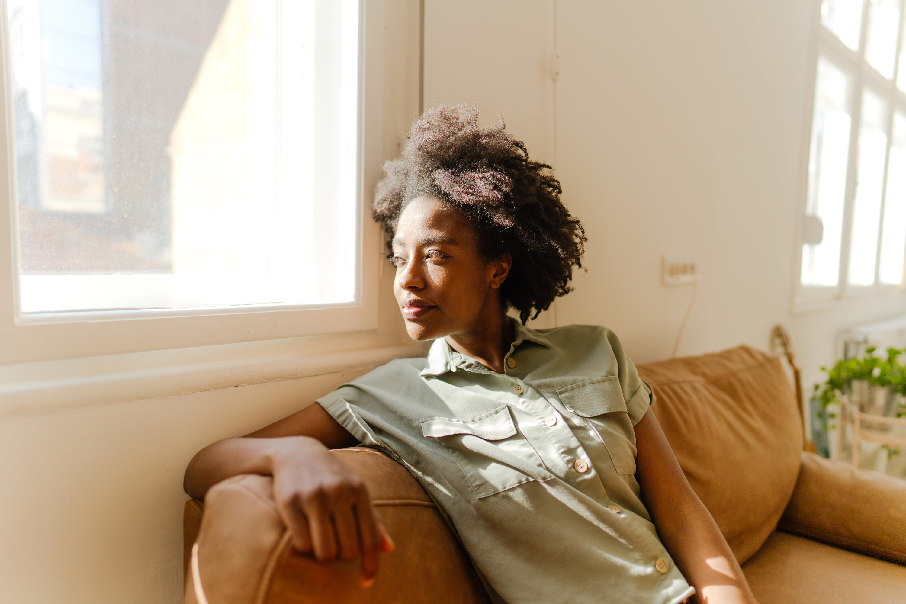 Young woman enjoying rays of sunshine in her living room