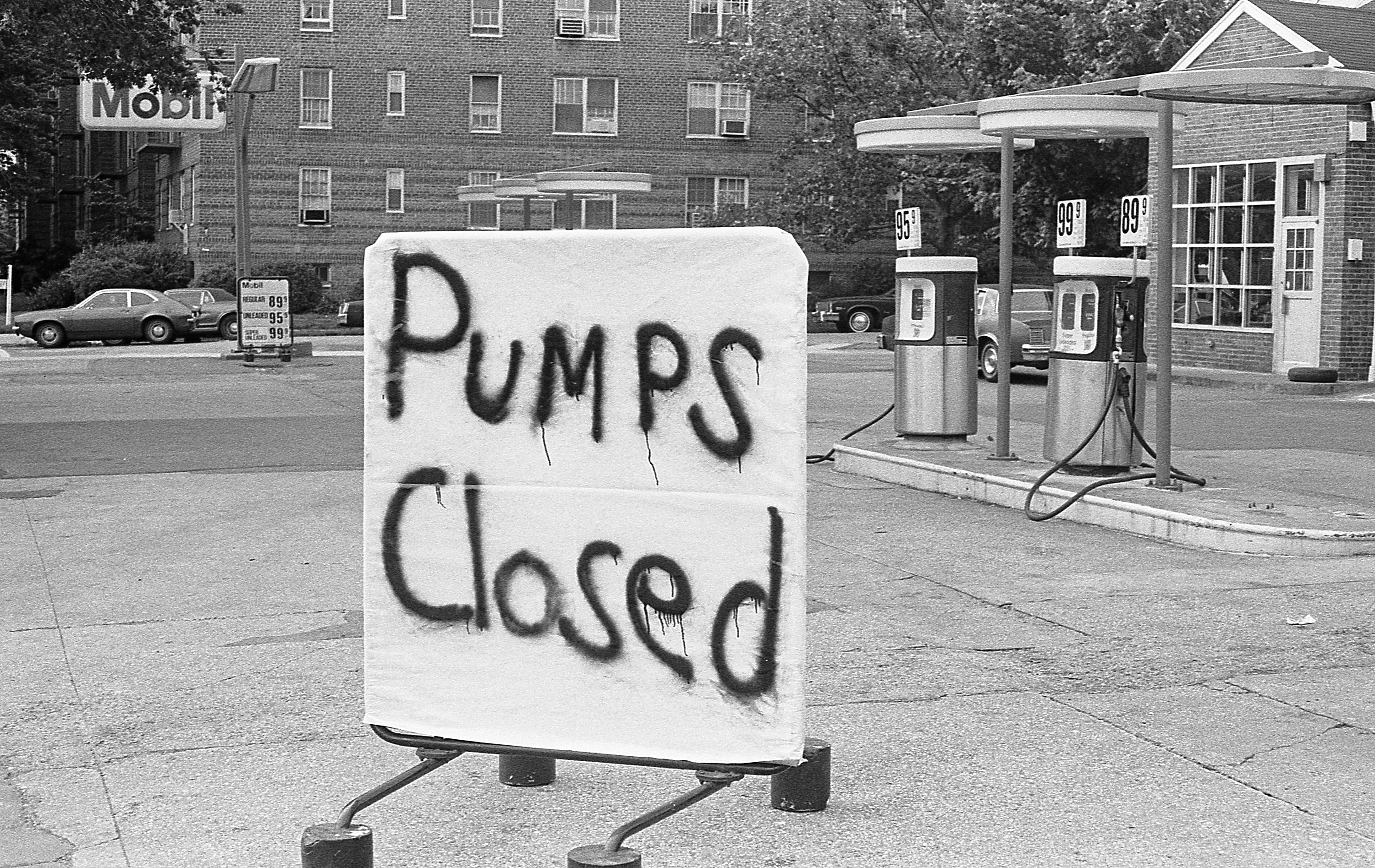 A spray-painted sign reads &quot;pumps closed&quot; outside a gas station