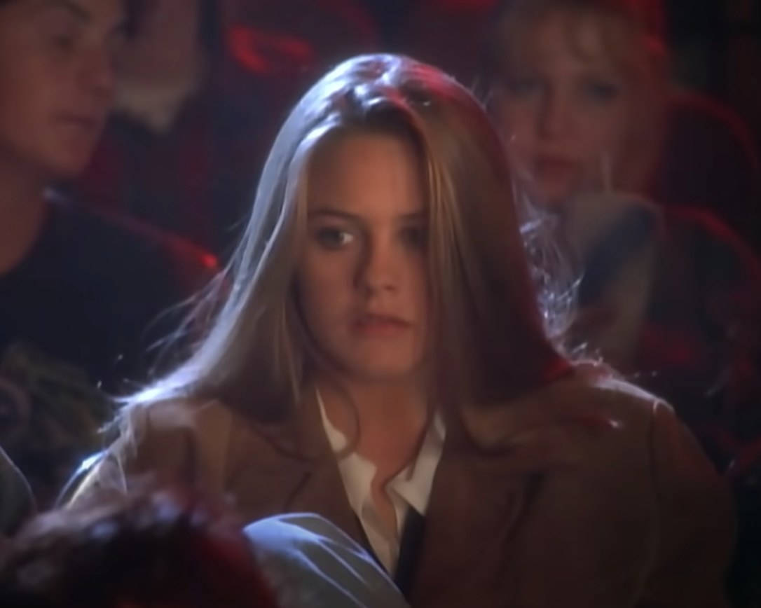 Alicia Silverstone sits in a movie theater as she acts in the &quot;Cryin&#x27;&quot; music video