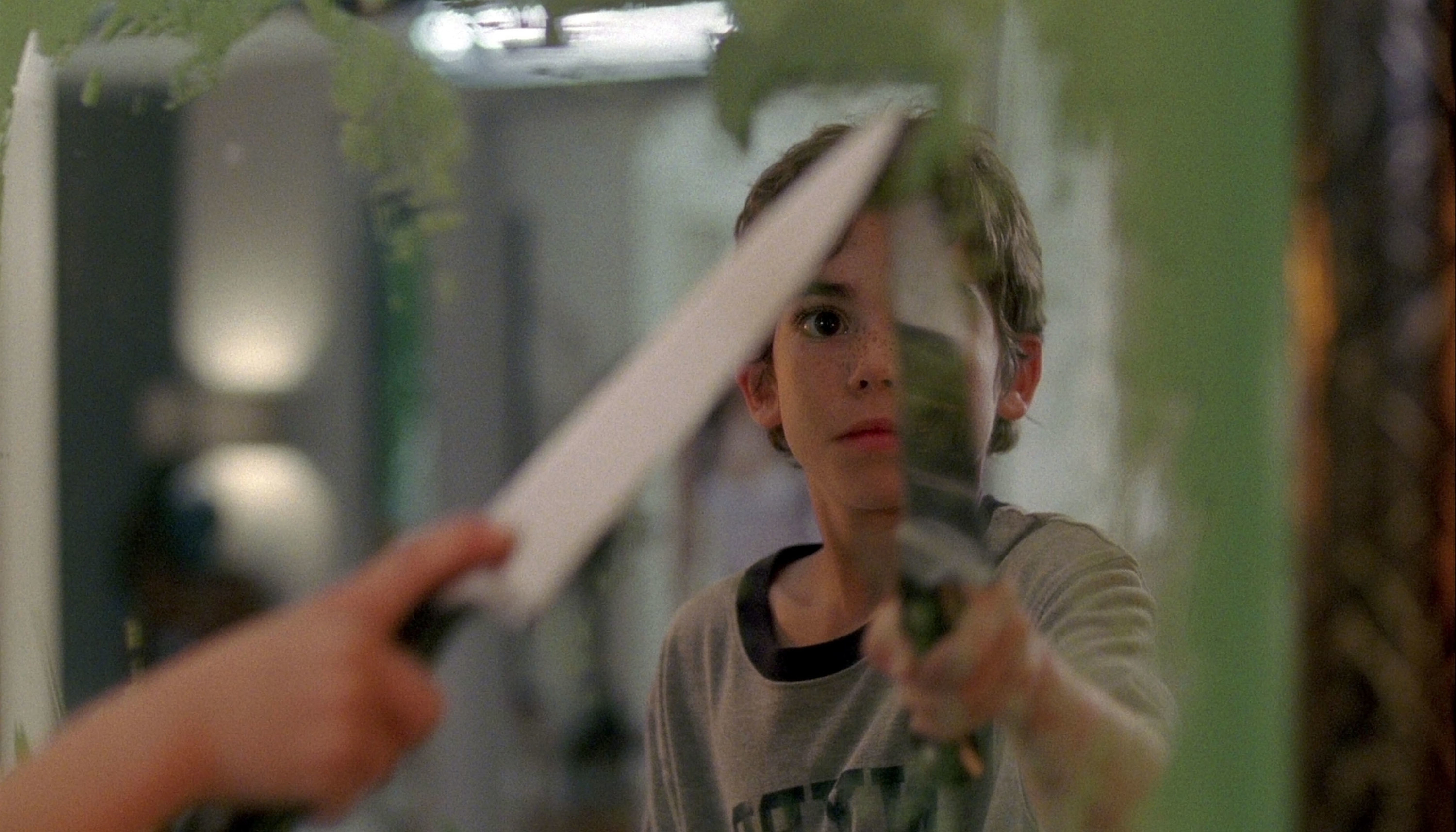 一个小男孩拿着一把刀,一面镜子