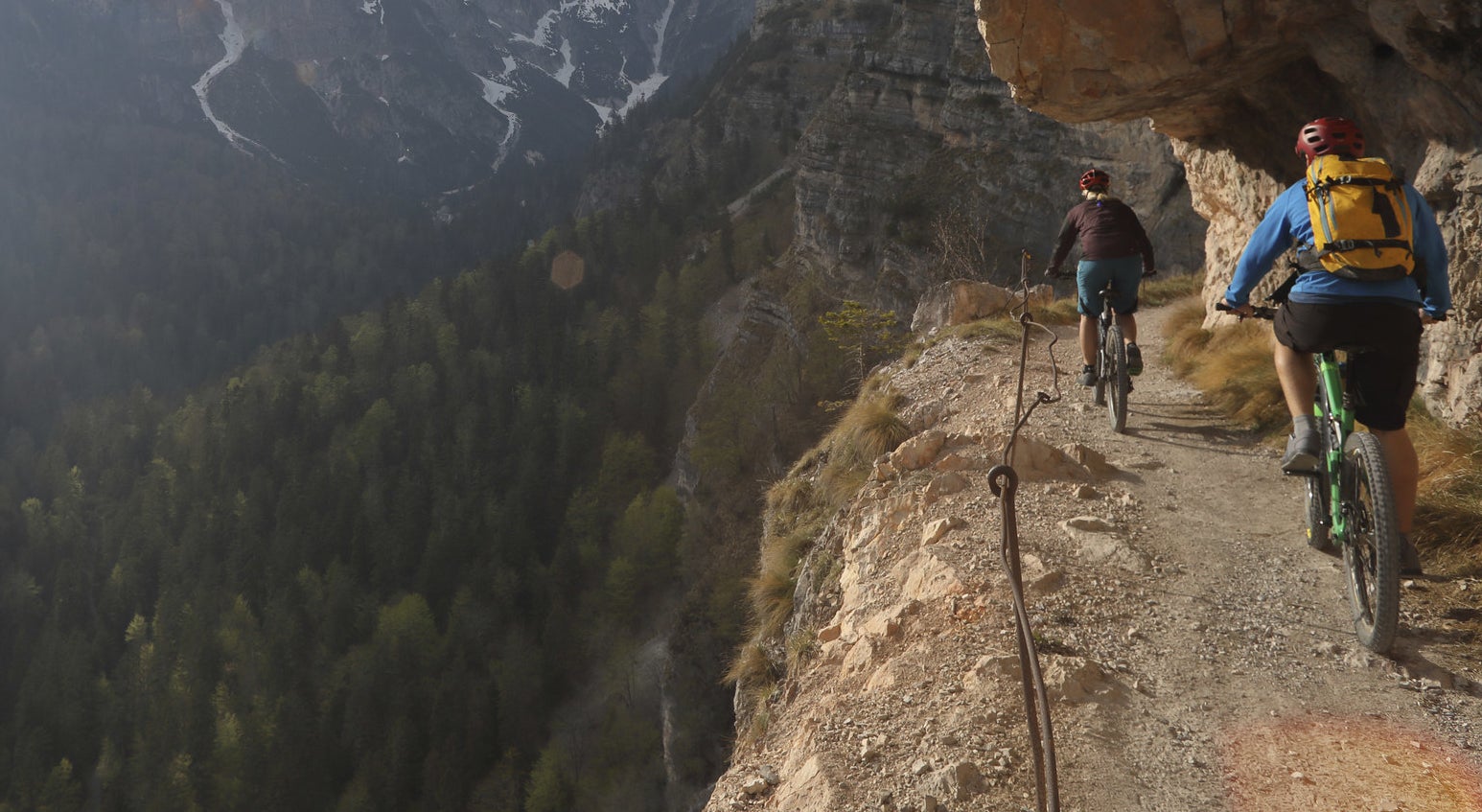 Mountain bikers alongside a steep and narrow path on the mountainside
