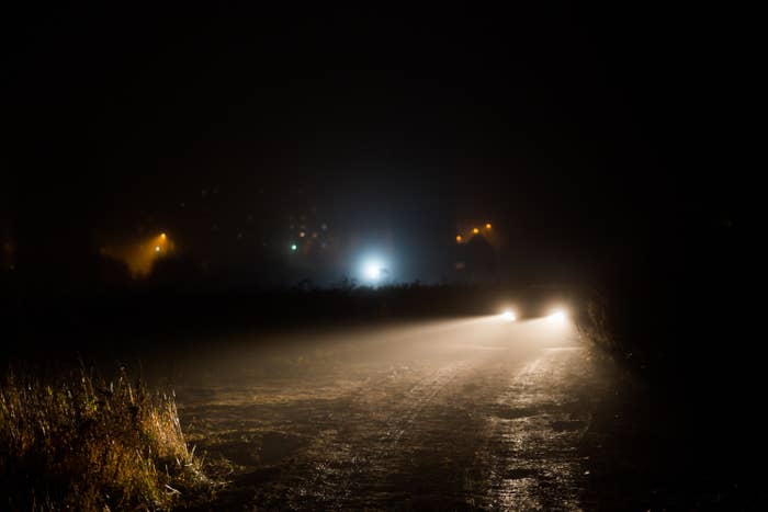 Headlights of a car shining on a dark road