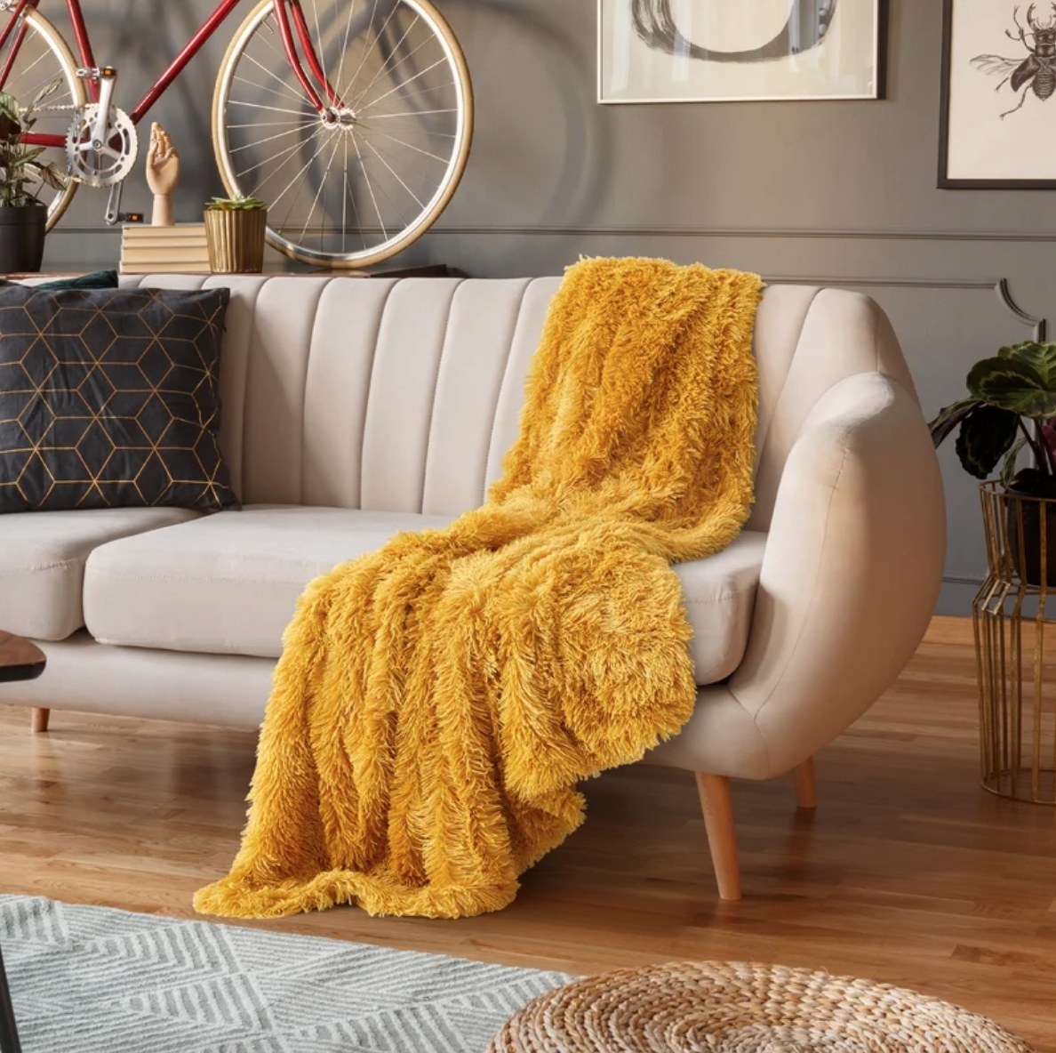Mustard yellow faux fur blanket on beige couch