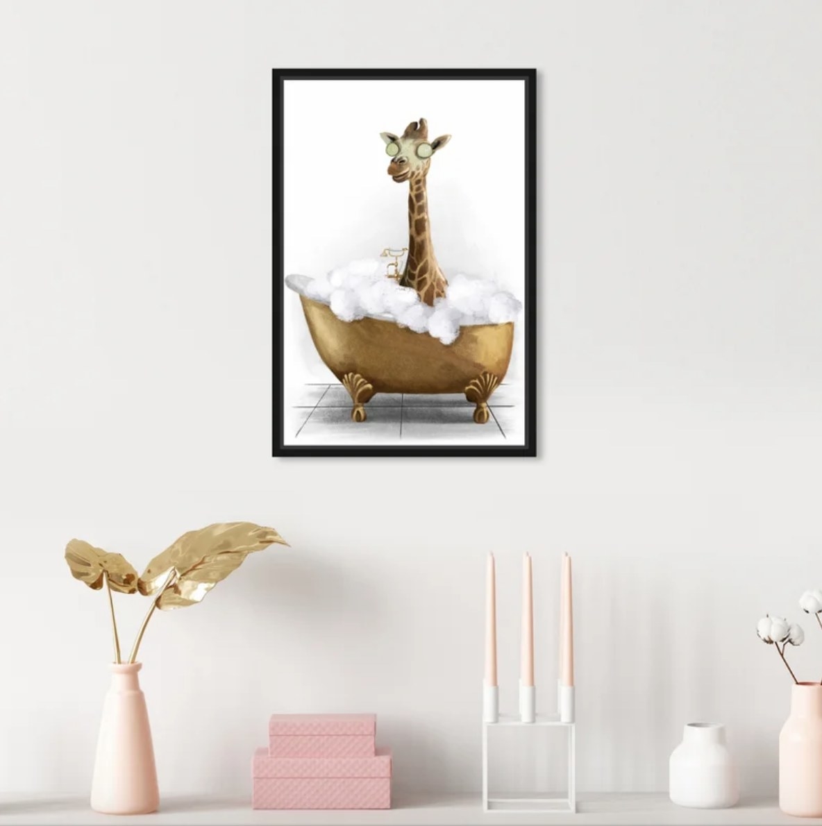 Picture of giraffe taking a bath on the wall above vases, boxes, candles