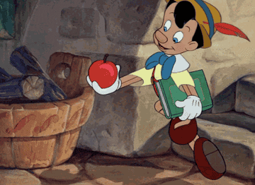 The animated Pinocchio skipping while holding an apple in one hand and a book in the other