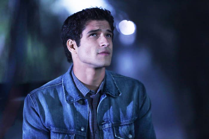 Tyler Posey wearing a denim jacket and looking up