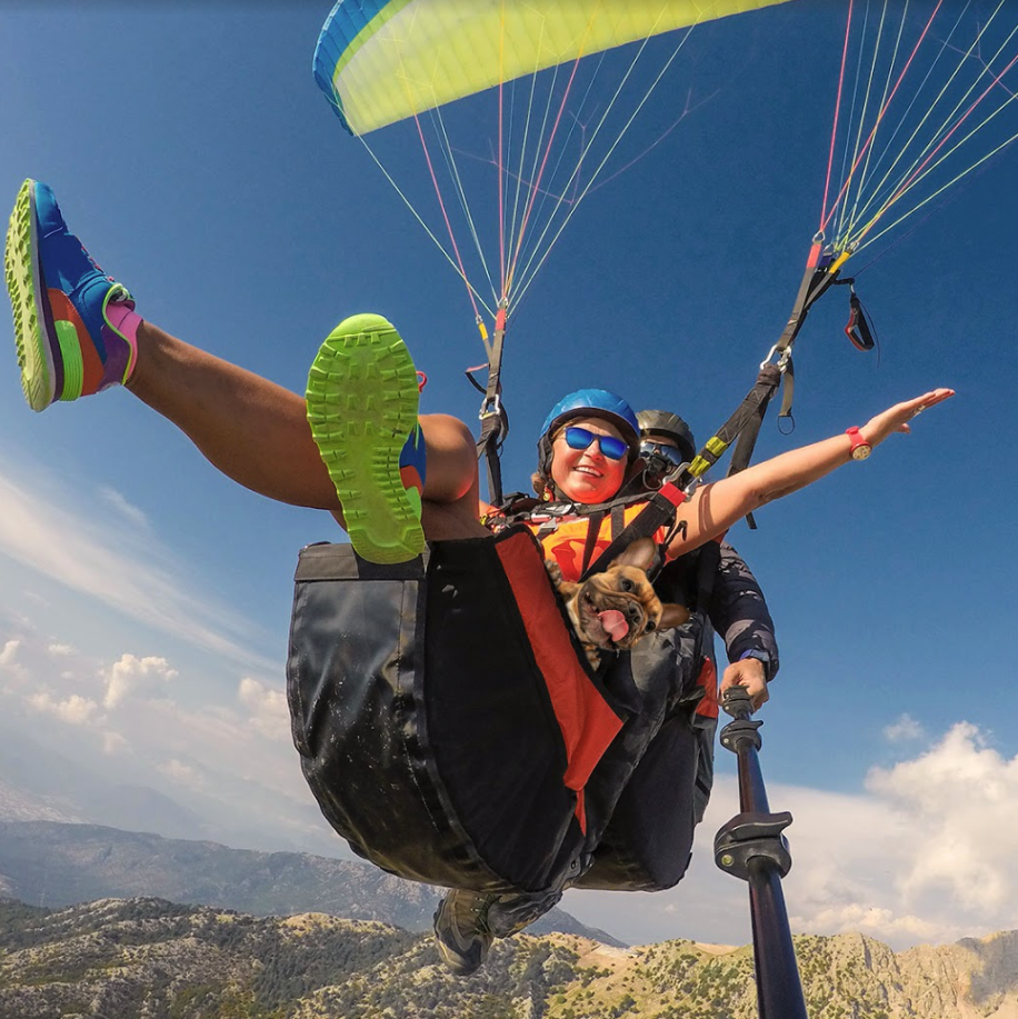 Two people paragliding with a dog