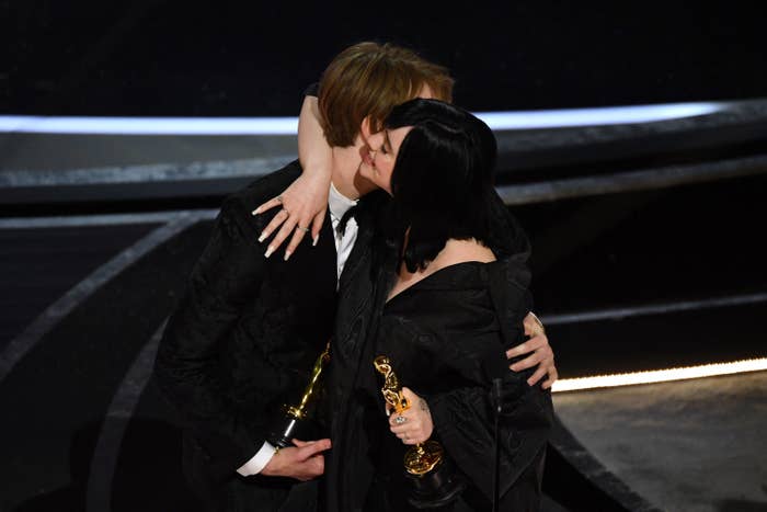 the siblings hug on stage holding their awards